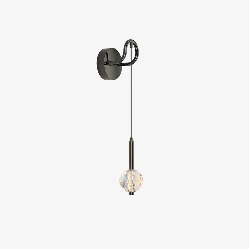 Isolated angled wall light with round dark plate at left, loop arm, long suspension and clear faceted globe