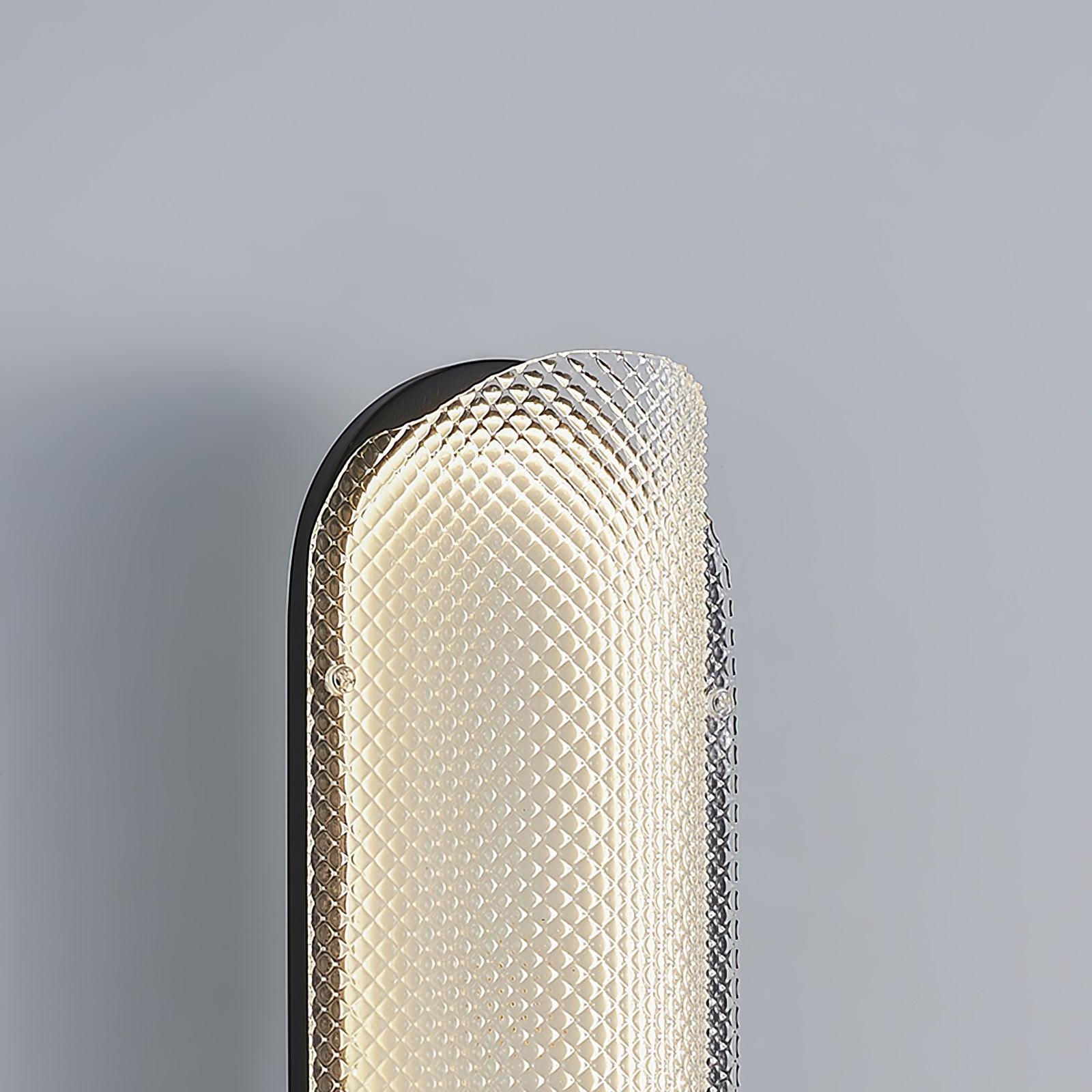 Close upper rounded end of the glowing diamond-textured glass lens with black plate behind