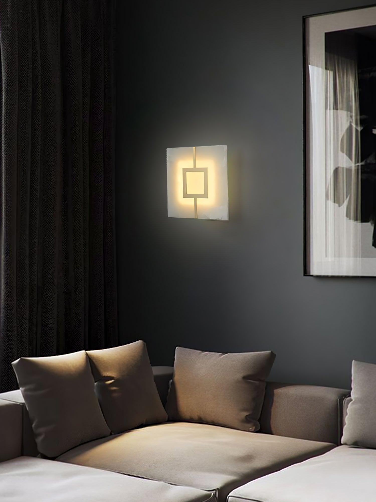 Portrait seating corner with square geometric wall light above a grey sofa beside artwork and curtains