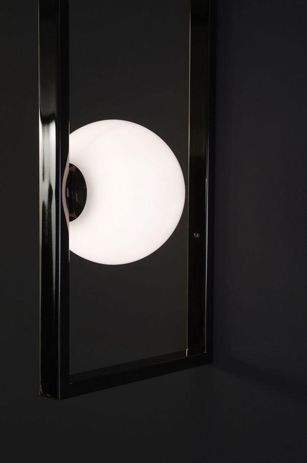 Illuminated globe behind a vertical Black rail