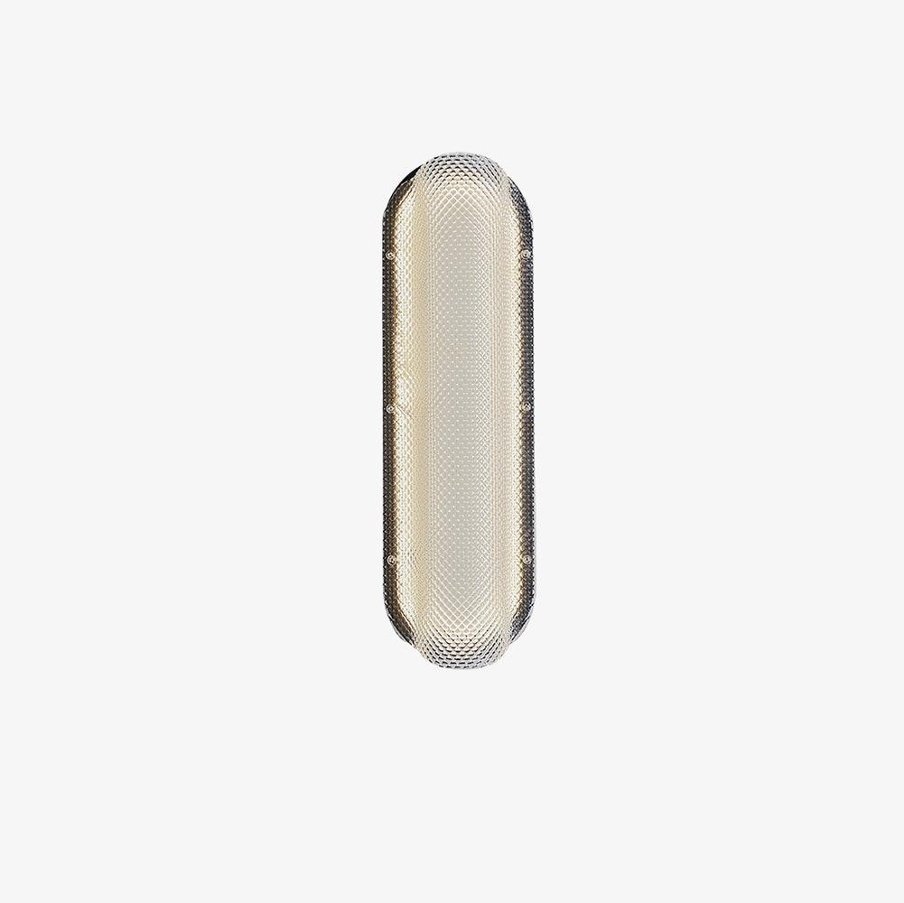 Isolated lit prismatic clear glass wall light with rounded ends and side fixings on a black plate