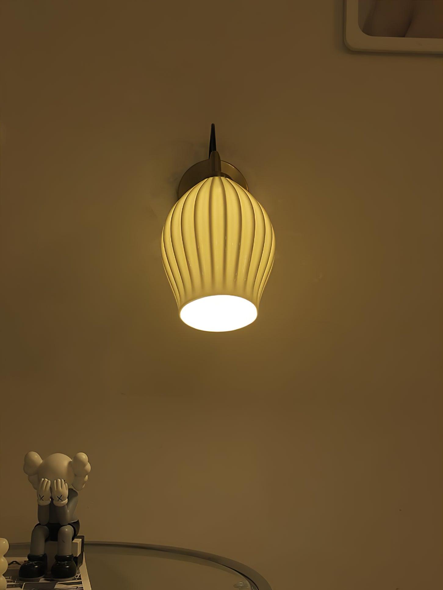 Warm-lit ceramic wall light in a dim room
