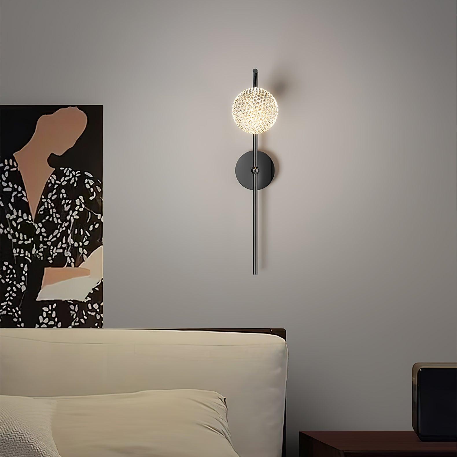 Black stem wall light above a bed