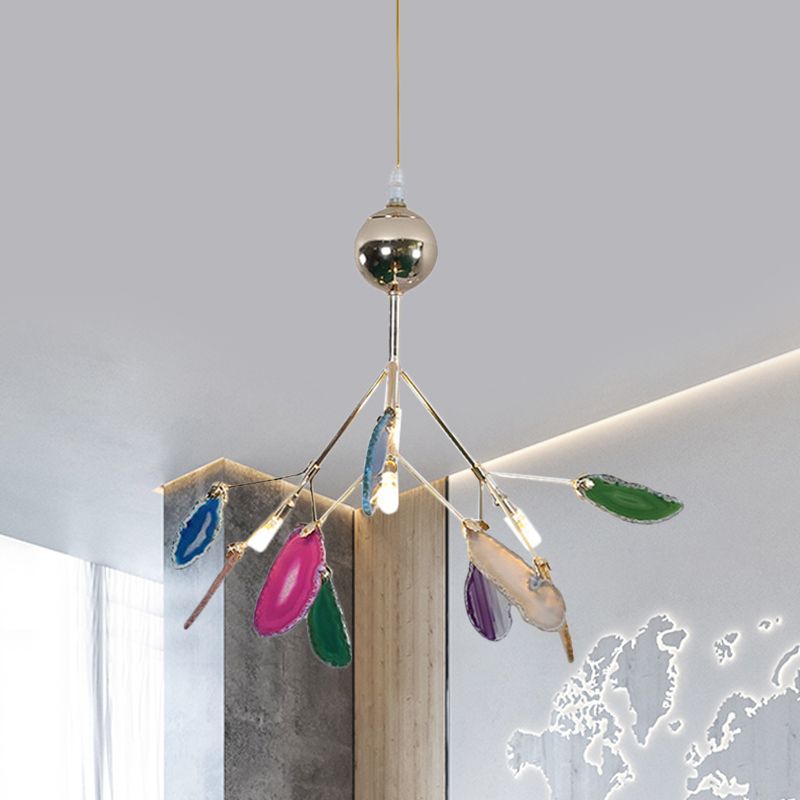 Compact multicolour stone-leaf pendant beside a wood panel and illuminated map-shaped wall artwork