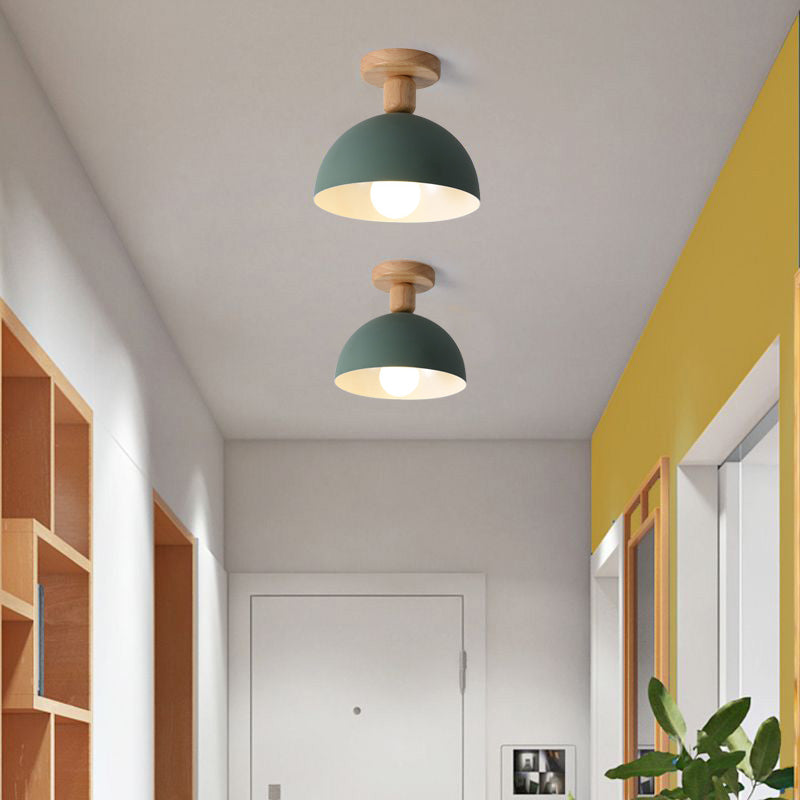 Green Ozawa Dome ceiling lights in hallway with yellow wall, wood-framed mirror, plant, cubby shelves and white entry door