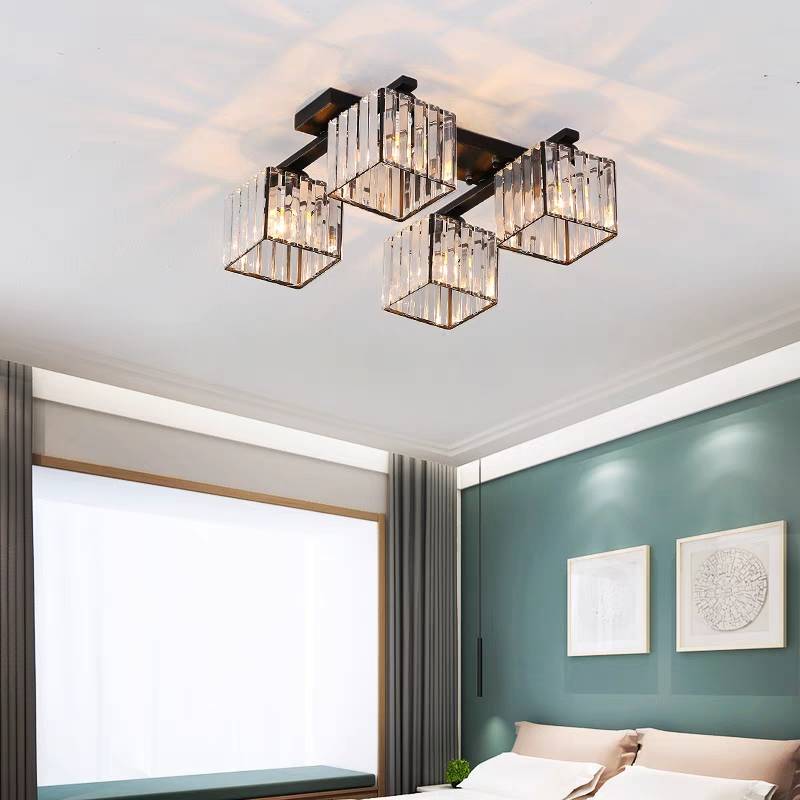 4-light Black Kristy ceiling light above a teal bedroom wall, two pale artworks, light pillows, broad window and grey curtains.