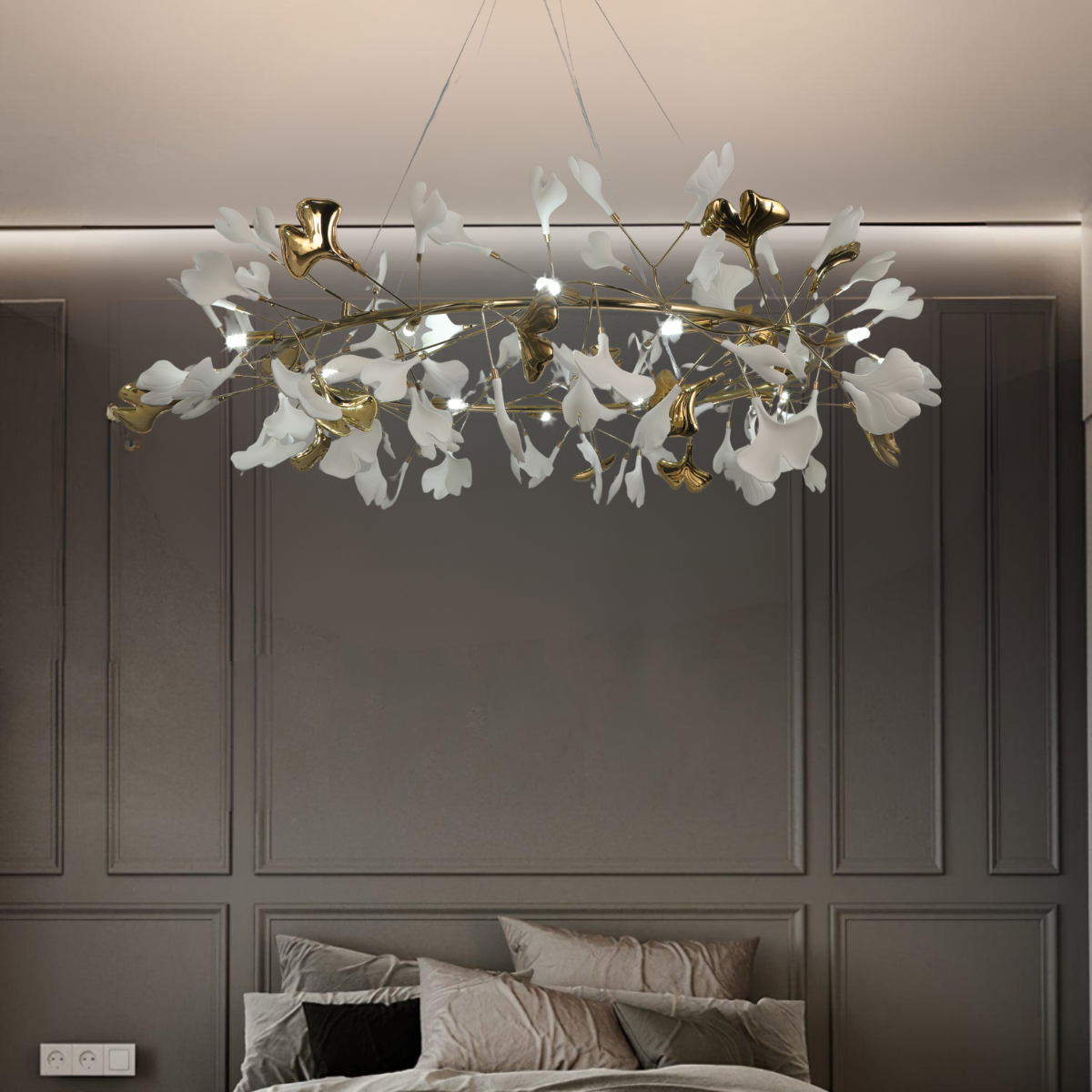 White and gold-colour leaves on a chandelier above a bed
