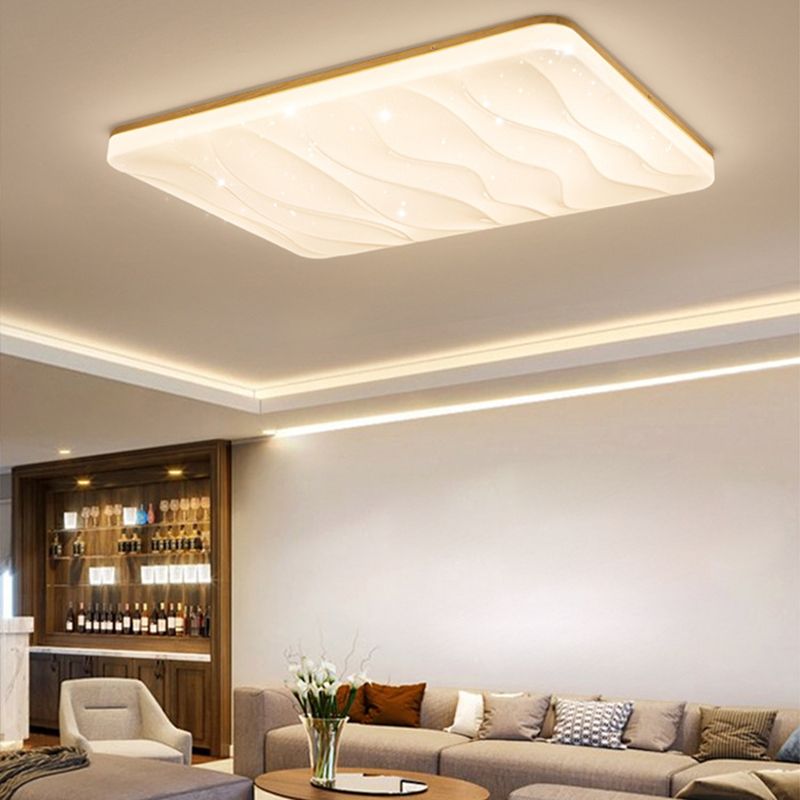 Rectangular Ozawa rippled ceiling face above a gray sofa and orange cushion, flowers on an oval coffee table and a dark glass-fronted cabinet.