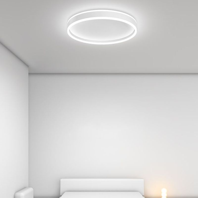 White Quinn round ceiling light with cool illumination above a bed