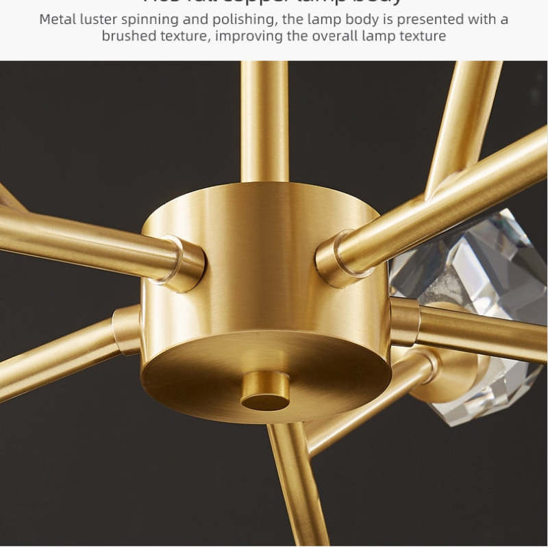 Kristy close-up of the cylindrical gold-tone hub and branching arms, with a clear faceted element behind.
