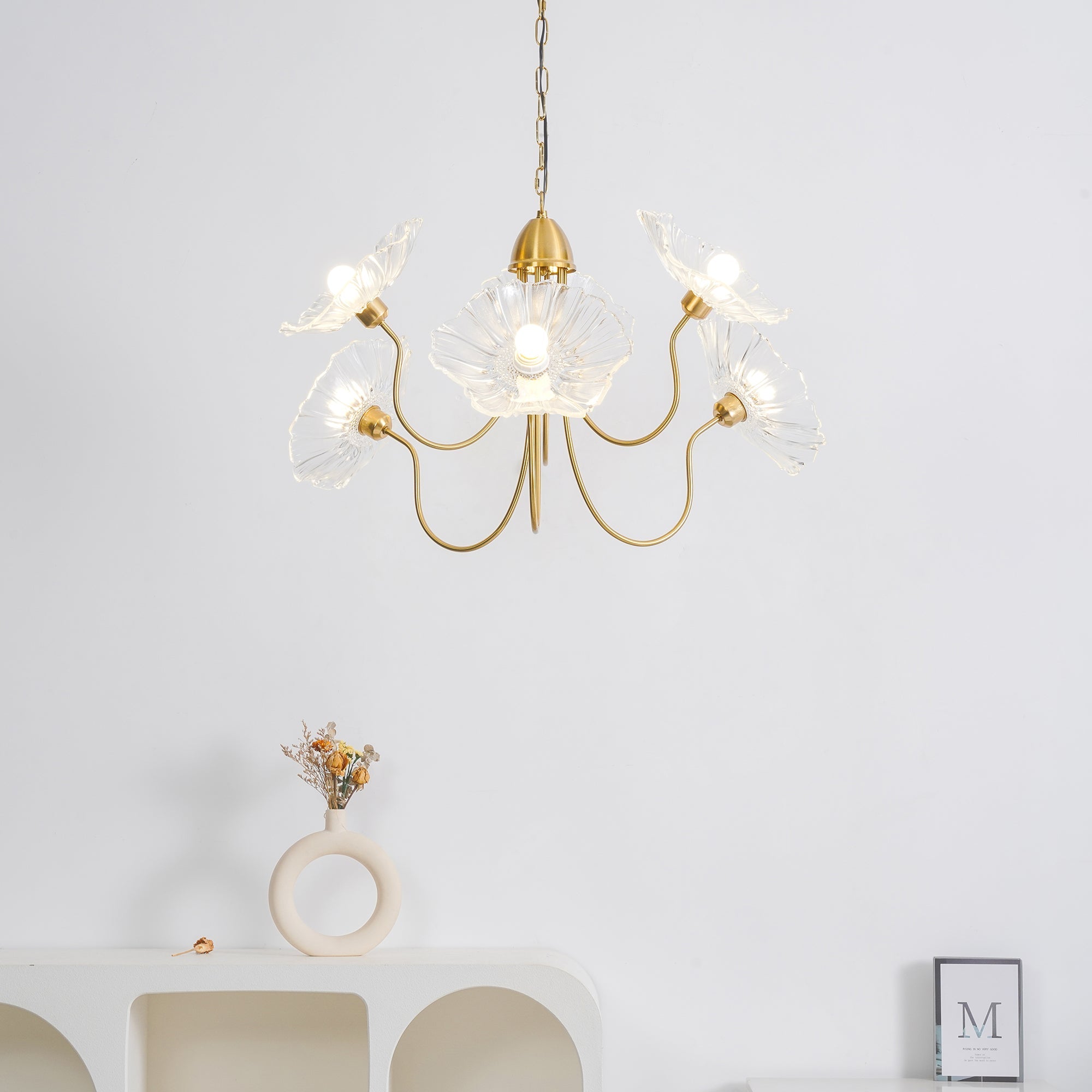 Illuminated clear flower chandelier in pale room