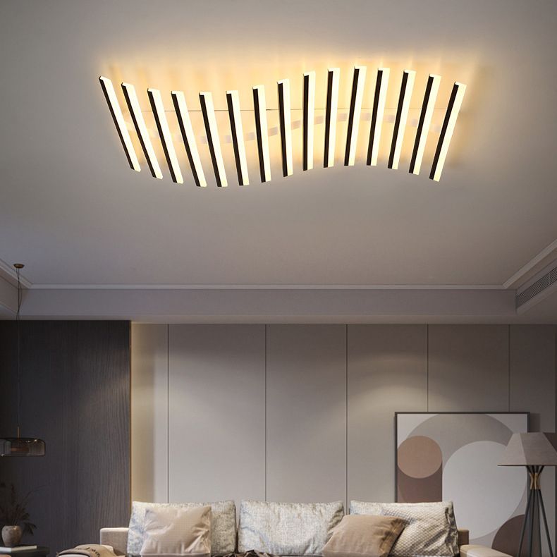Quinn piano-key-style ceiling light above a pale sofa, blue and tan cushions, abstract artwork and a separate floor lamp.