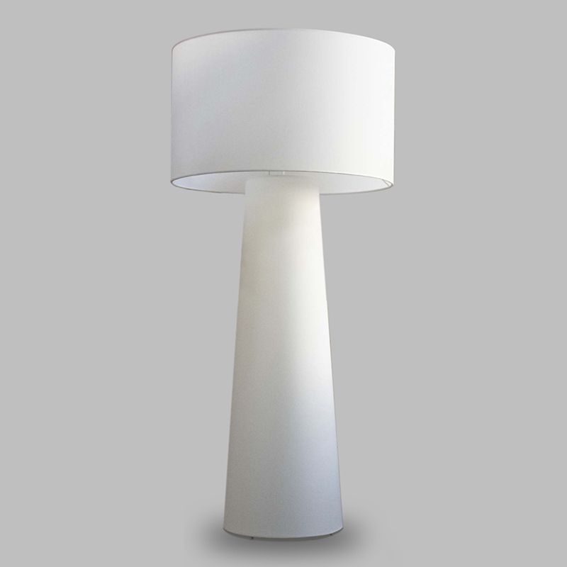 Unlit pale fabric drum-shade floor lamp with a tapered lower body on a gray background