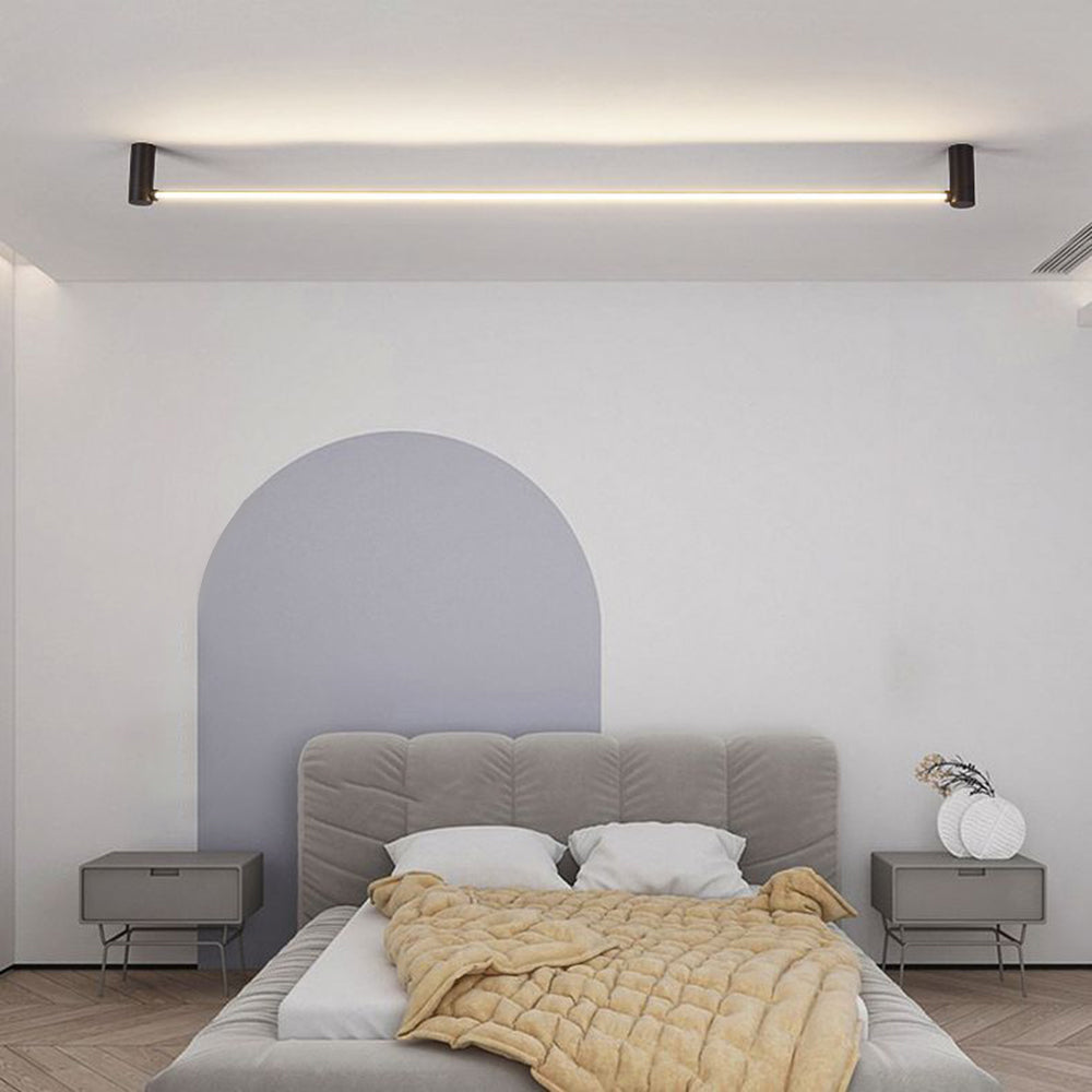 Edge above a grey upholstered bed, mustard-yellow quilt, bedside units and a pale arched wall feature.