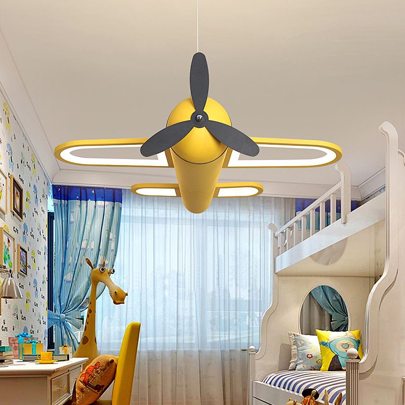 Yellow Minori airplane pendant with dark decorative propeller, lit above a bedroom.