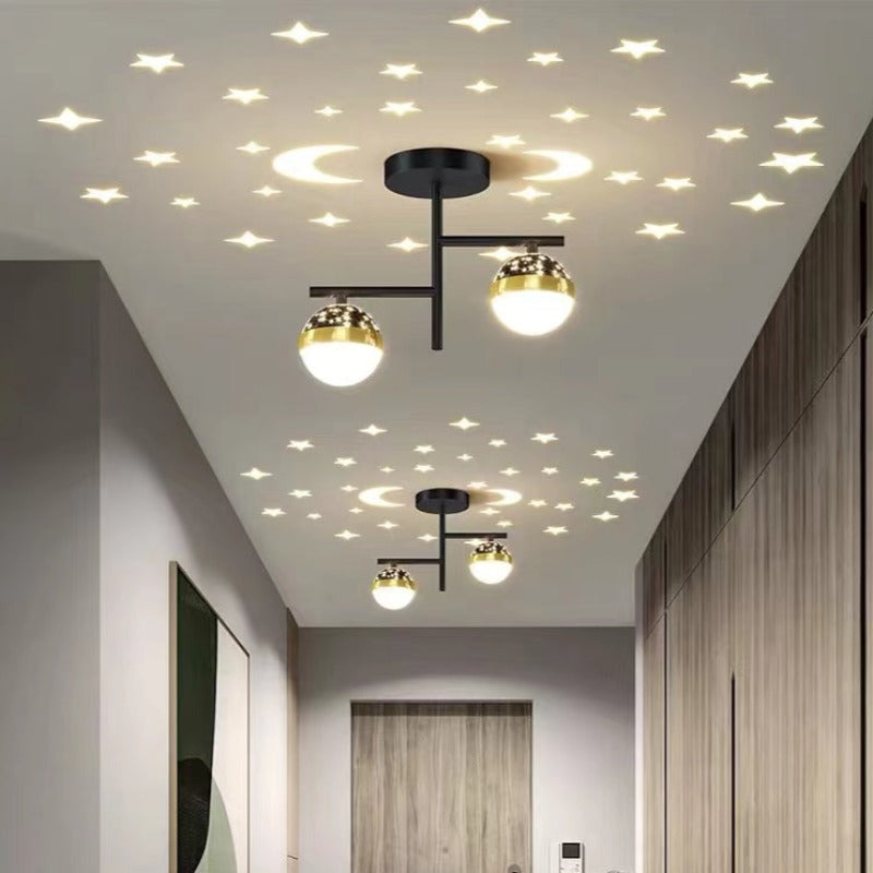 Black-frame Madina globe lights along hallway with wood slat wall, curtains at end, green artwork and illustrated stars and moon