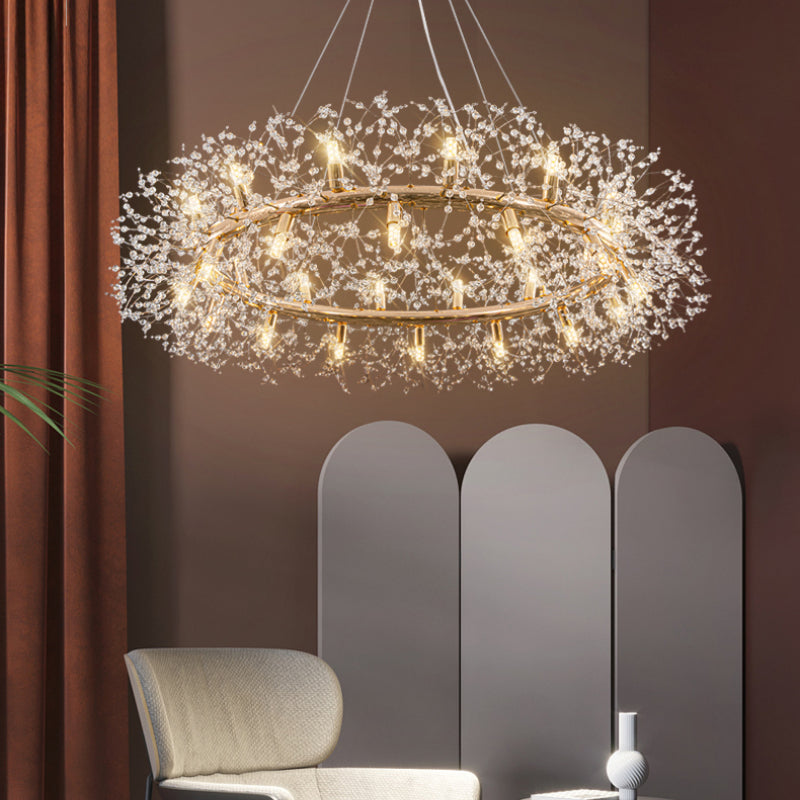 Angled underside of Lili’s gold-coloured ring and clear crystal branches, before a brown wall, rust curtain and pale arched screen.
