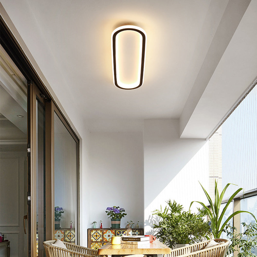 Black Quinn light above wicker chairs, wood table, books, cups, patterned tiles and many plants beside window blinds.