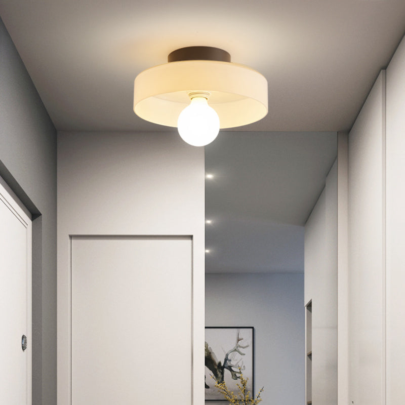 White Morandi ceiling light with an exposed globe bulb in a hallway
