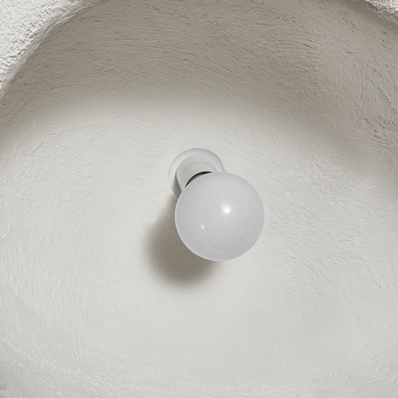 Inside a white textured Byers shell, a single globe bulb is pictured in a holder.
