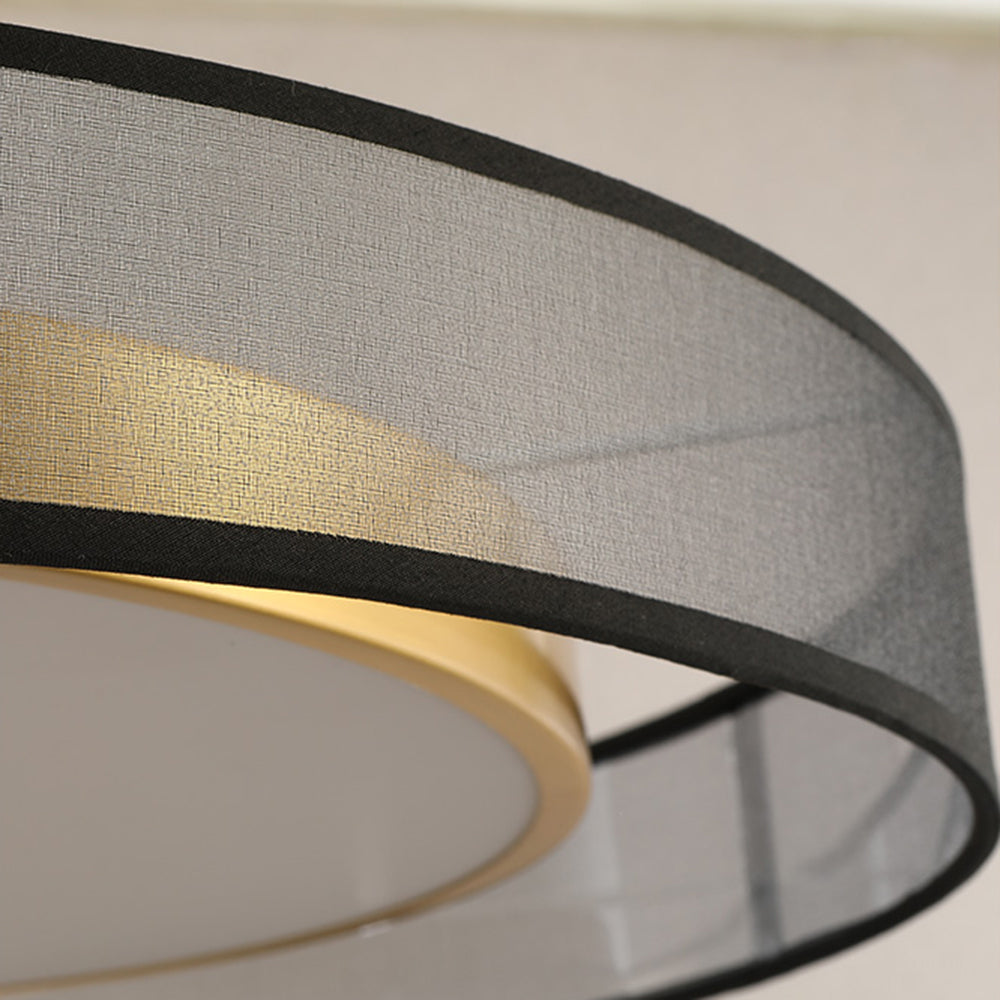 Close-up of the fine textured grey outer drum, black rim strips, gold inner band, pale diffuser and a support behind the shade.