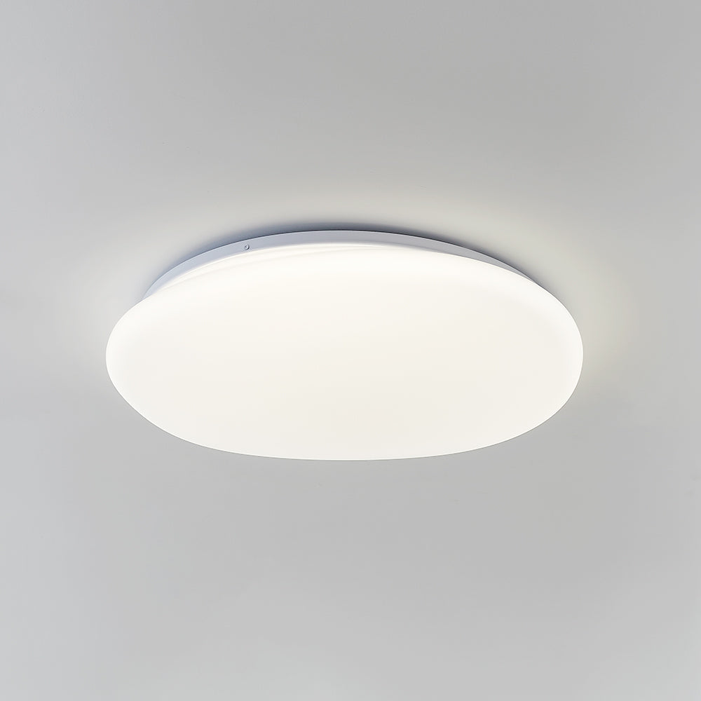 Oblique underside of Quinn pebble ceiling light with neutral-looking luminous face, irregular edge and pale rim.