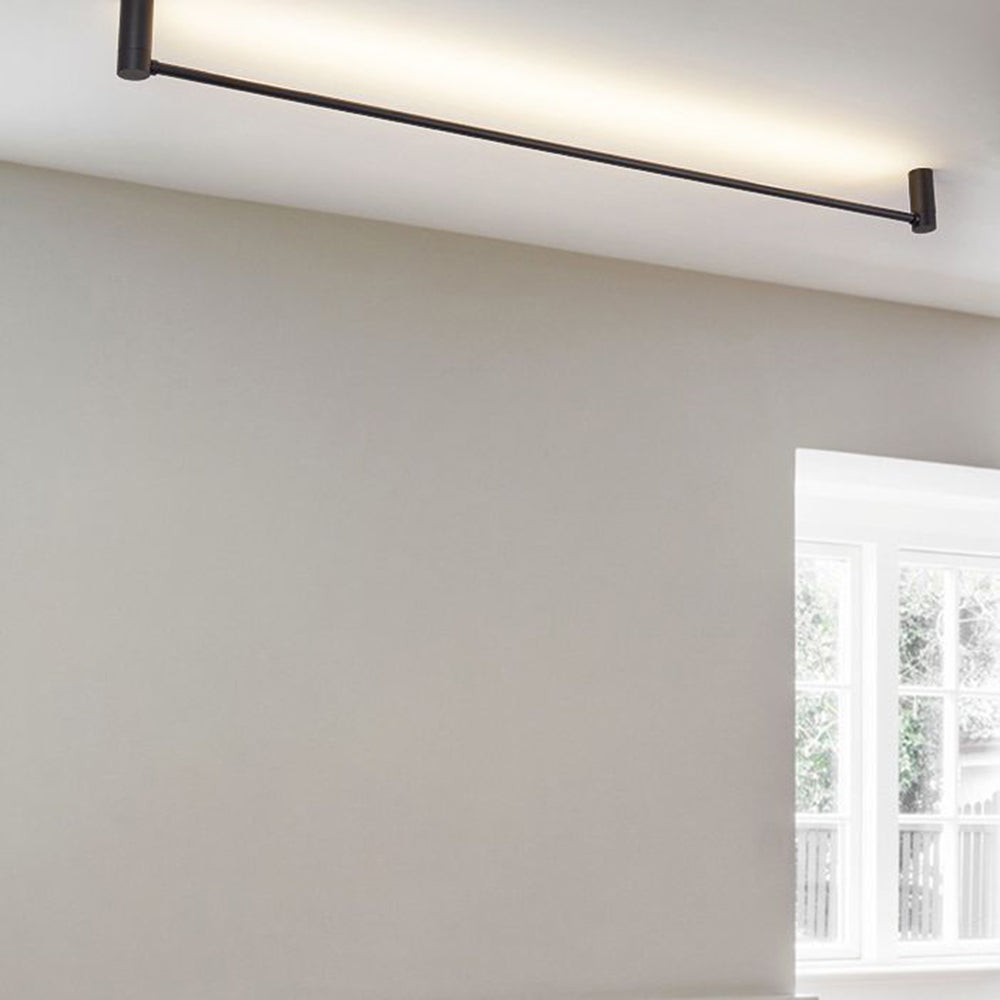 Edge angled near the ceiling by a beige wall and multi-pane window, with two cylindrical supports and warm-looking wash.