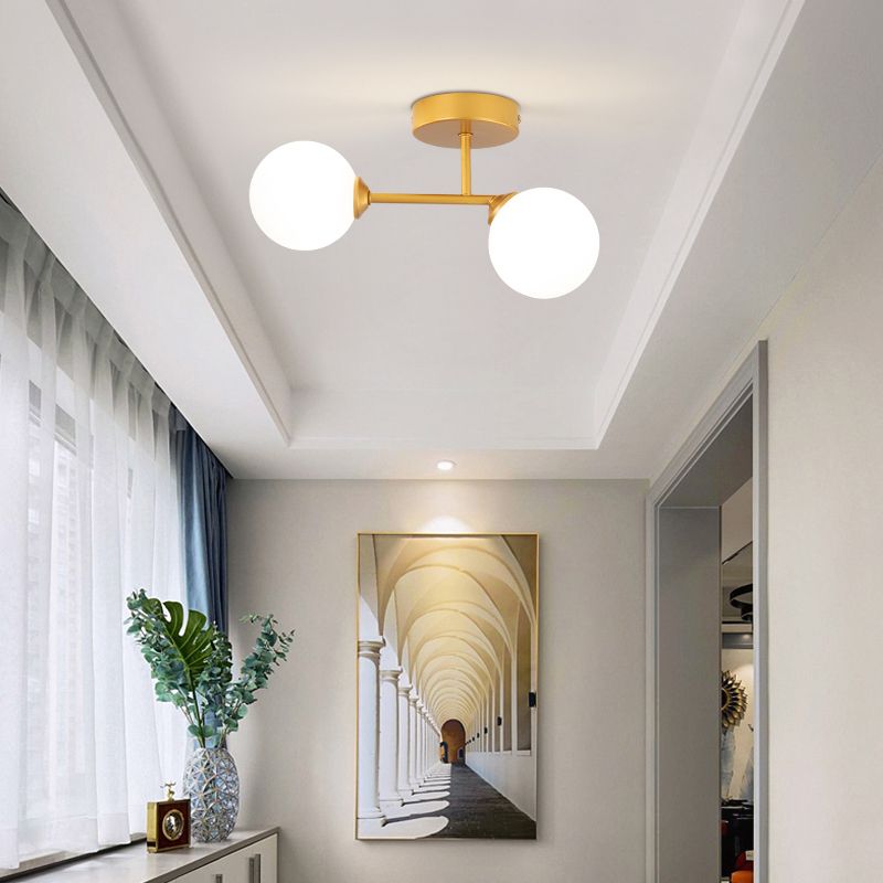 Gold Valentina under a tray ceiling above arched-corridor artwork, with curtains, a foliage vase and small clock.