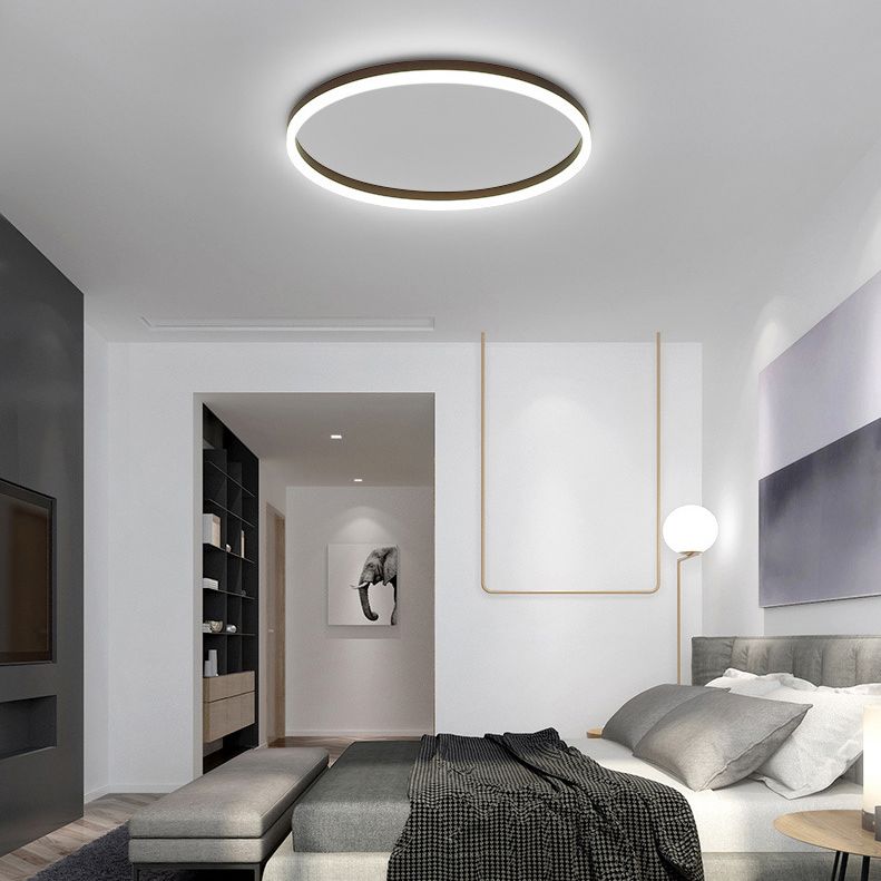 Quinn black ring ceiling light above a bed with dark grey bedding.