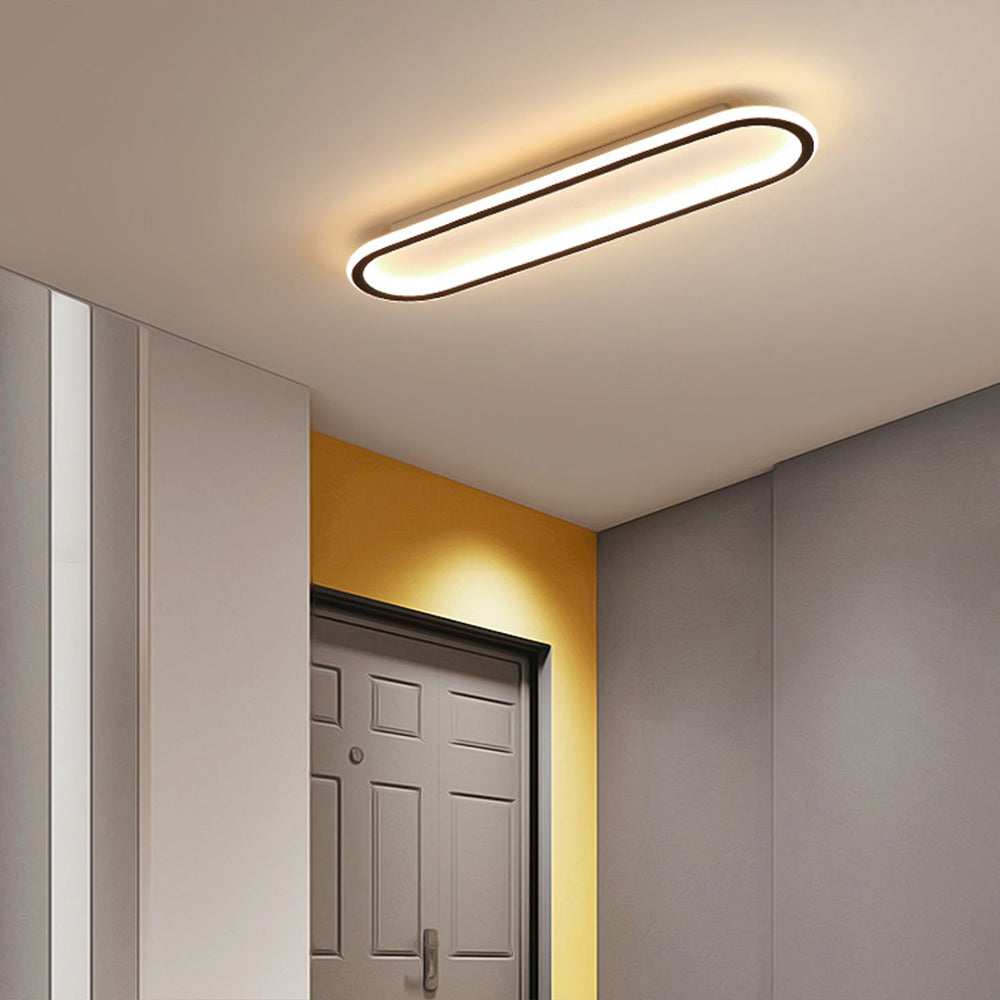 Black Quinn light over a grey paneled door with yellow accent surround, white cabinets and grey wall.