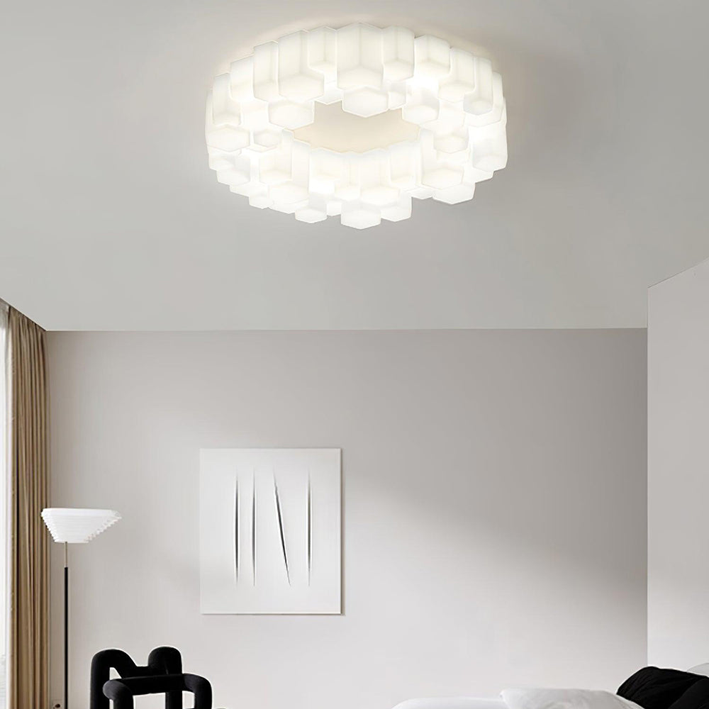 White Light Quinn above a pale living room with abstract artwork, a brown curtain, a black loop chair and a white sofa.