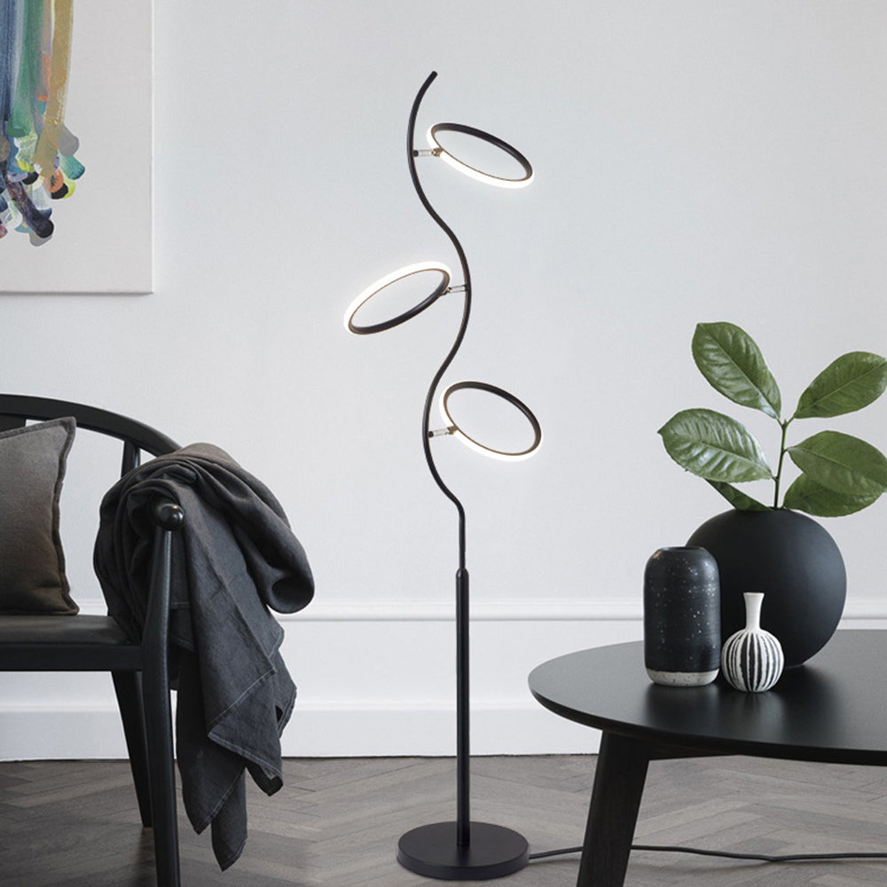 Louise Black floor lamp with rings at different angles beside seating