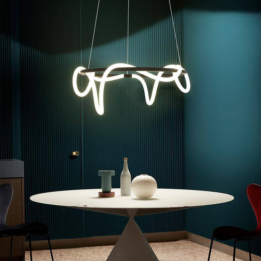 Dark Louise ring with luminous loops above a round white pedestal table and small vessels, against dark teal fluted walls.