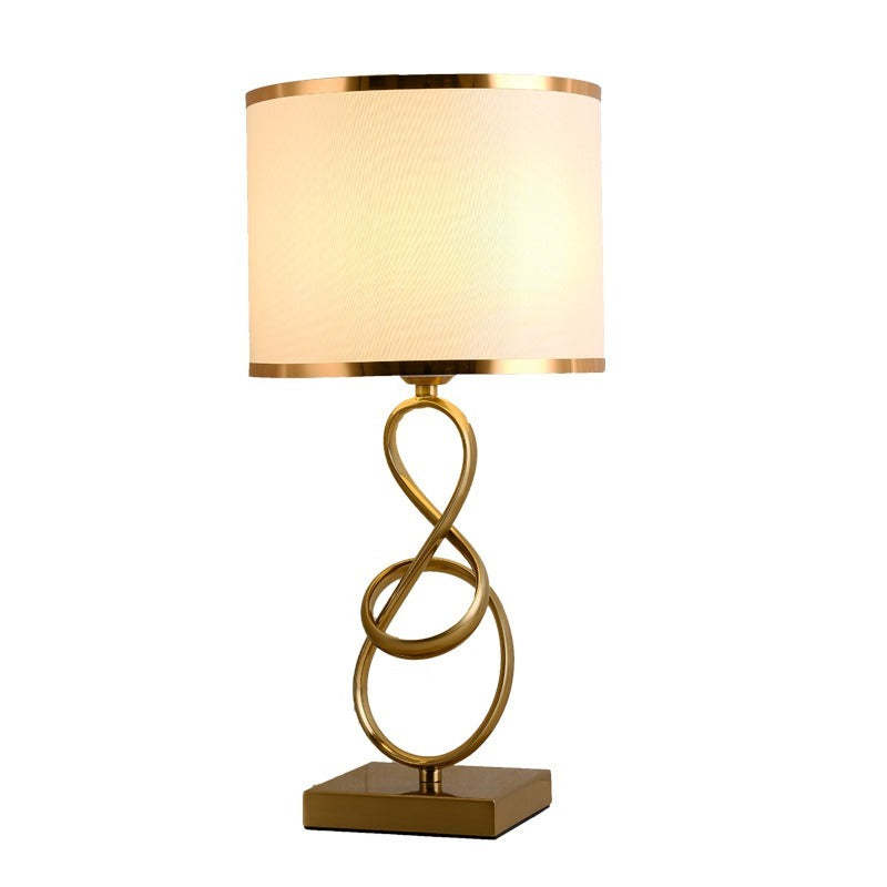 White-shade table lamp with looped metal support and square base