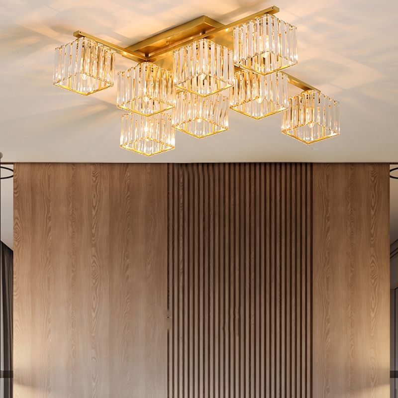 Eight gold-toned Kristy cube shades above tall wood-grain panels and a central vertical slat panel, with dark seating below.