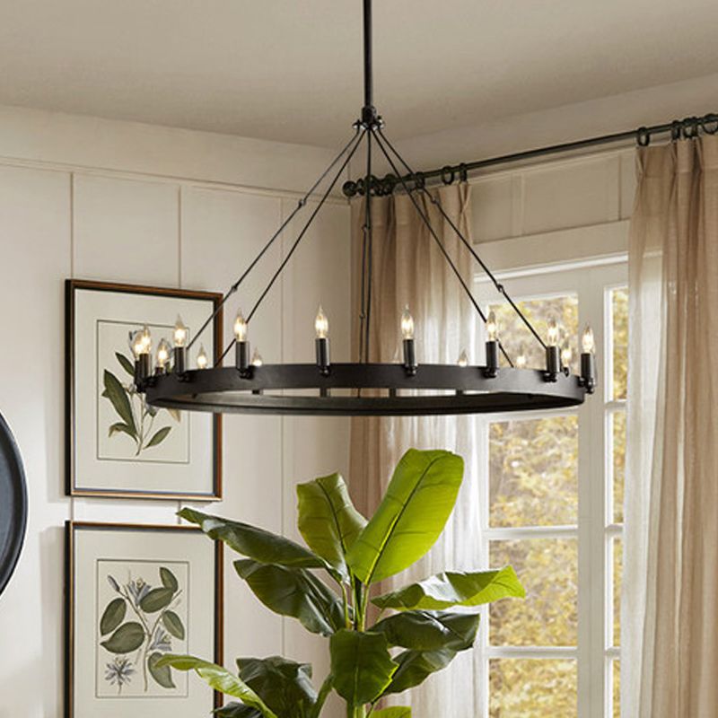 Large black Alessio candle-style ring pendant in a bright room with plants.