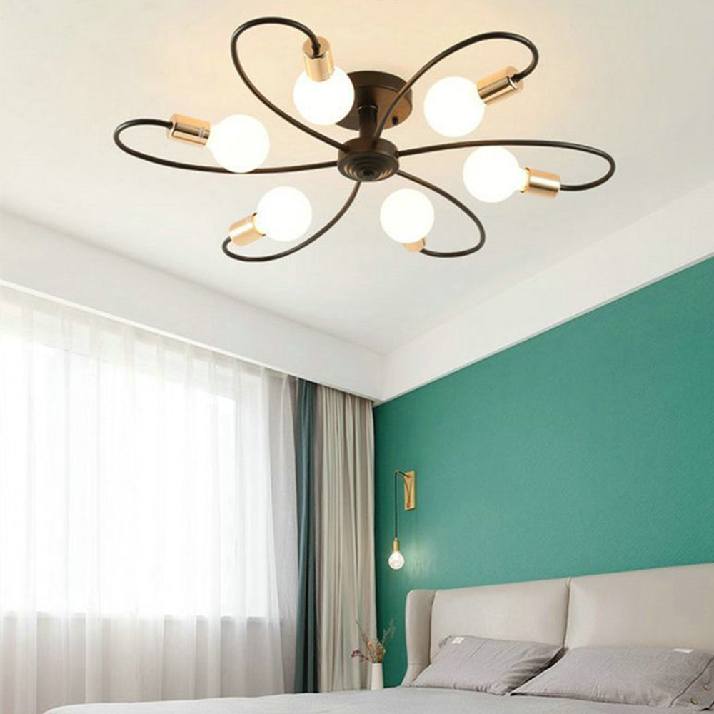 Valentina Black six-loop light above a pale headboard and teal bedroom wall, beside sheer curtains and a bedside bulb.
