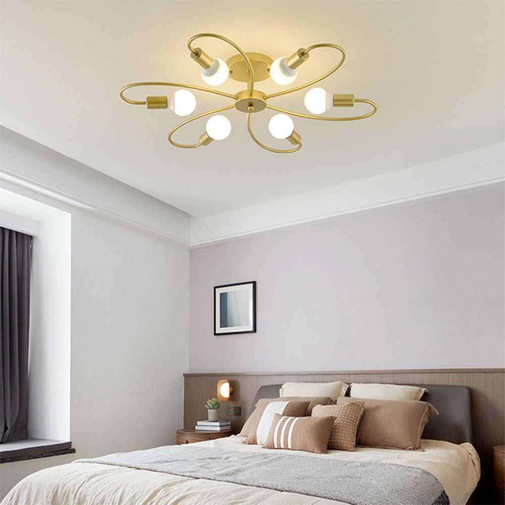 Valentina Gold six-loop light above a neutral bedroom with cream bedding, striped cushions and wood wall panels.