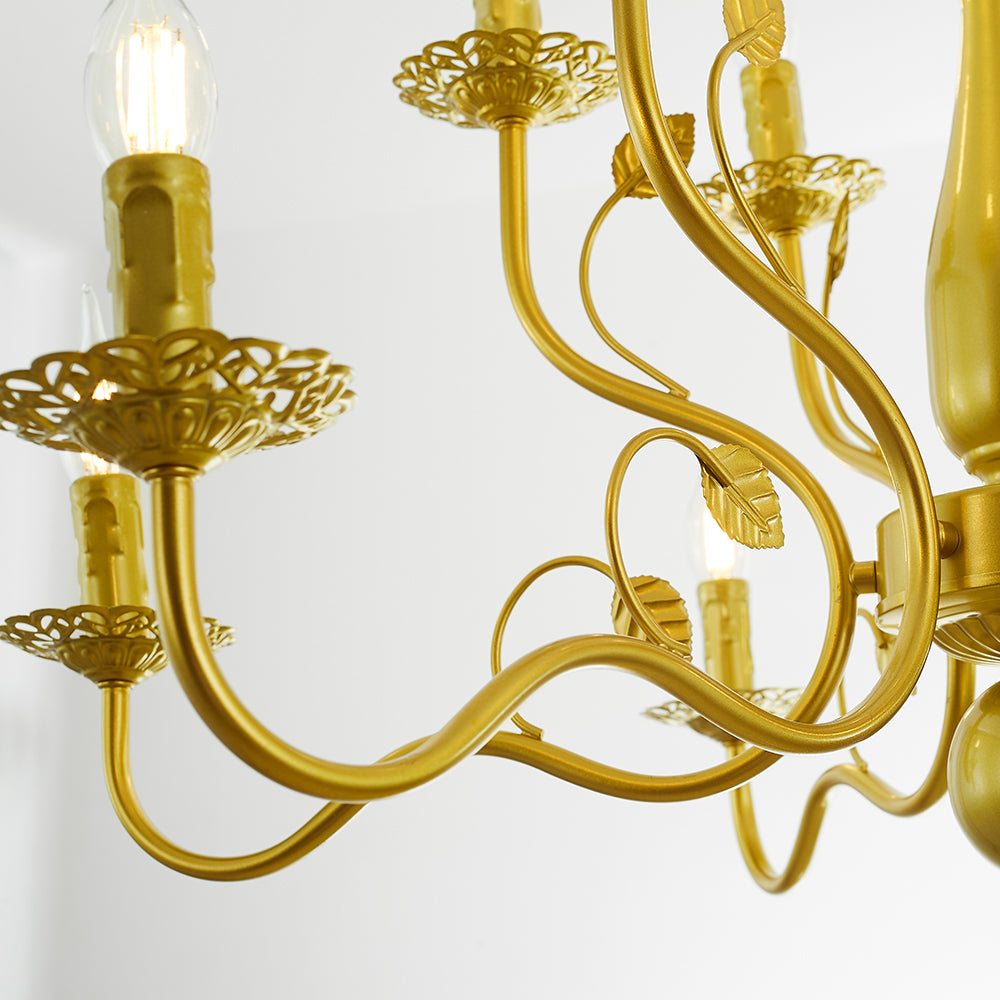 Close-up of gold Marilyn’s curled arms, leaf ornaments, pierced decorative trays and candle-like holders with clear flame-shaped bulbs.