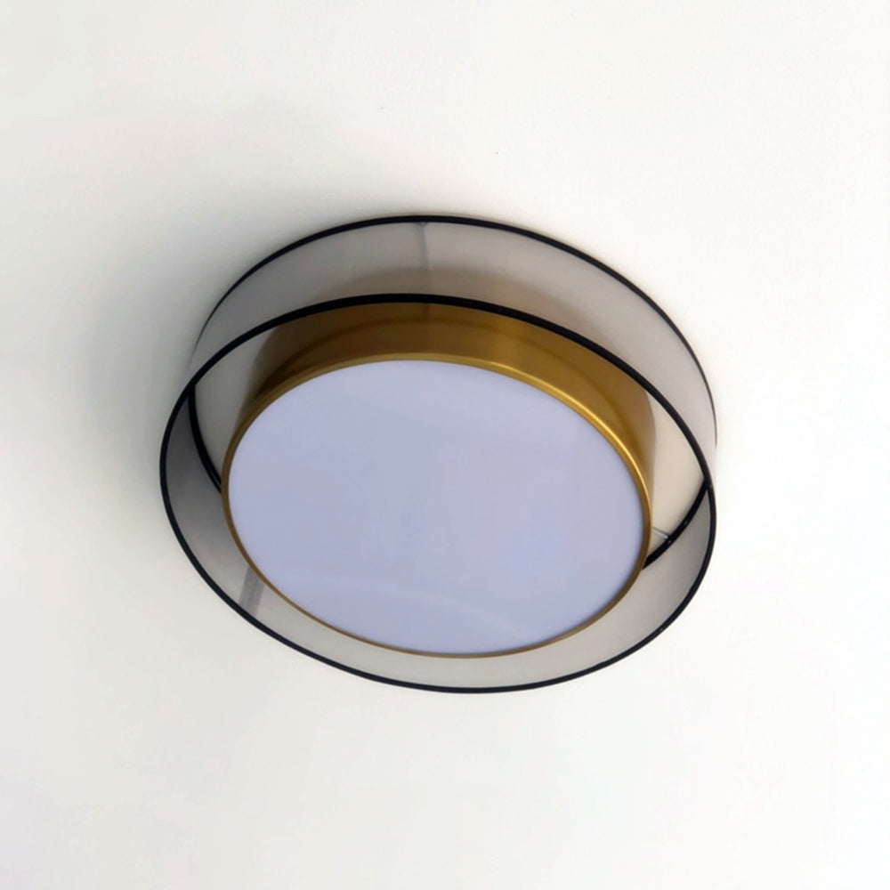 Quinn viewed from directly below, with pale circular diffuser, gold-tone inner rim, translucent outer band, black edges and supports.