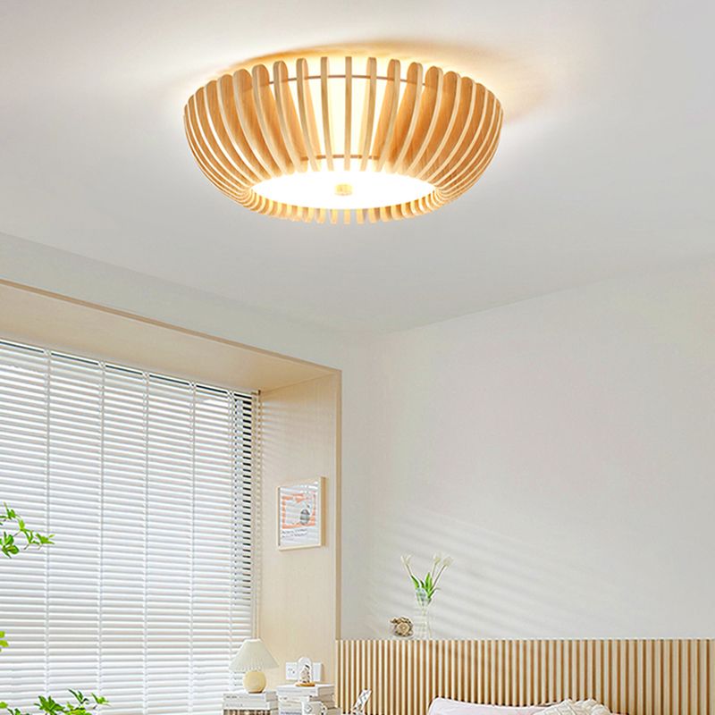 Ozawa ceiling light above a wood-slatted bedroom wall, beside window blinds, a bedside lamp, books and plants.
