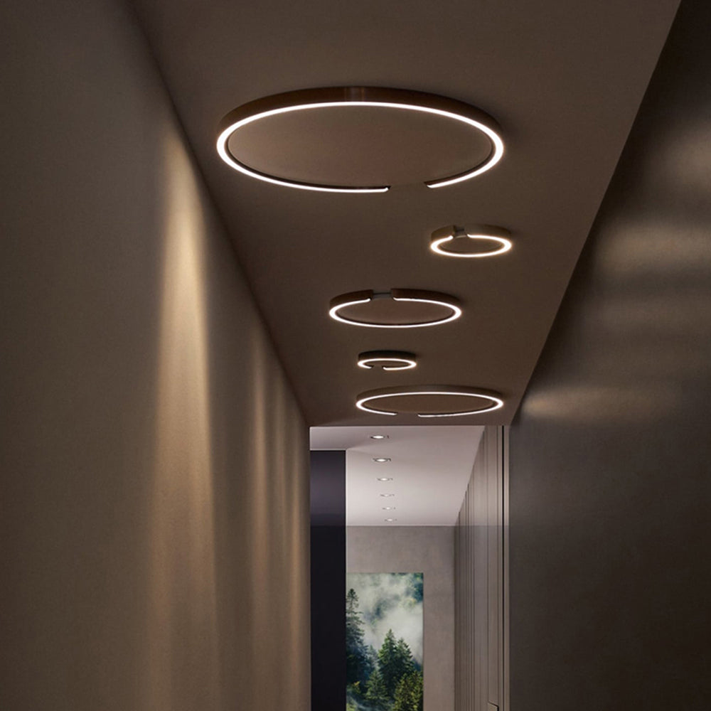 A row of illuminated Edge rings along a dark corridor ceiling