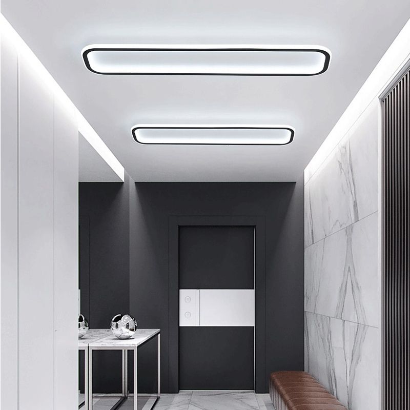 Two Edge ceiling lights in a long room with gray wall panels