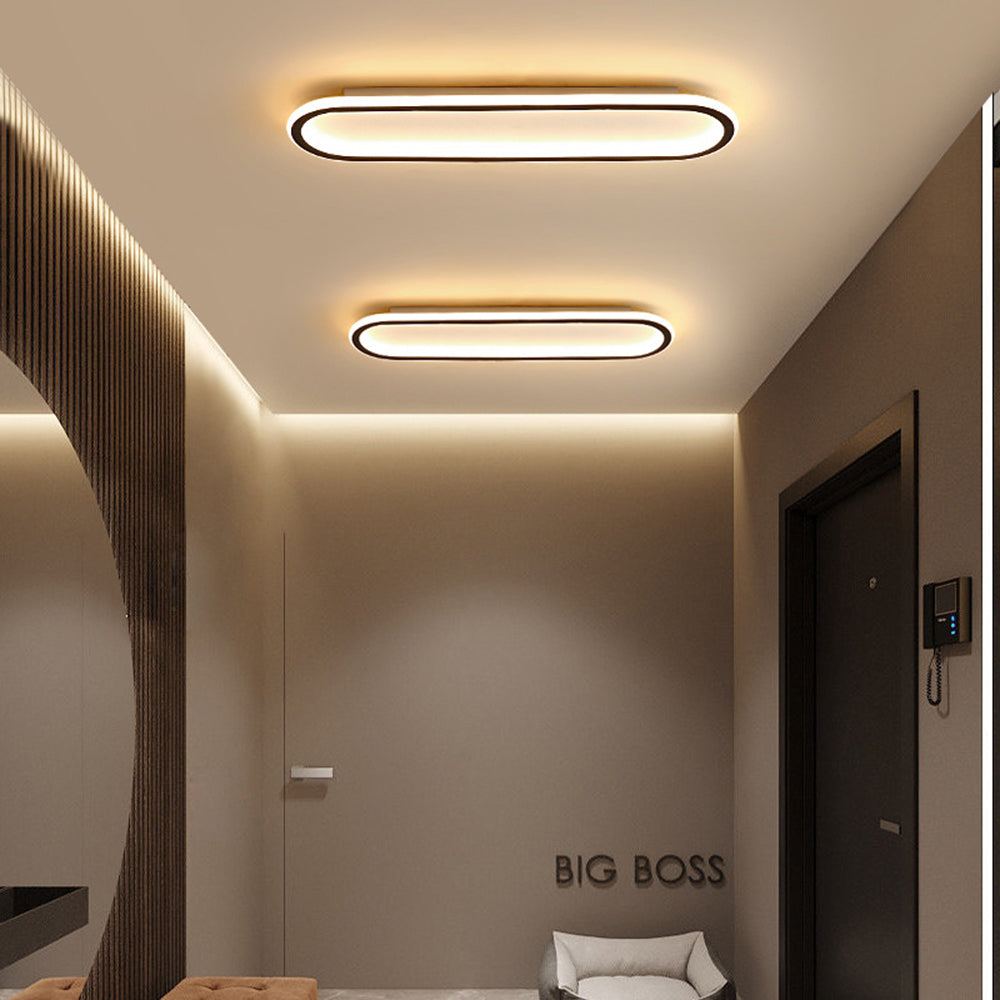 Two Black Quinn lights in an entry with slat wall, dark door, intercom, white chair and BIG BOSS lettering.