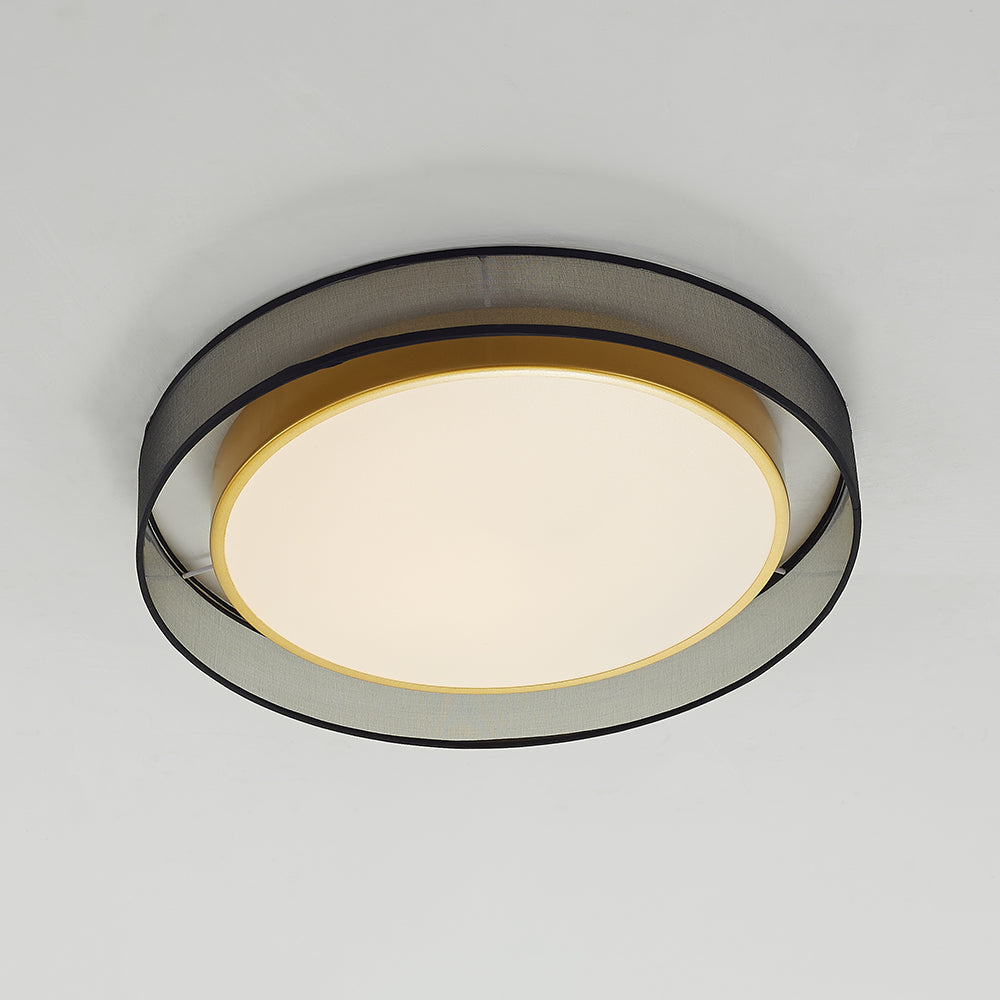 Closer underside angle of Quinn with a warm-looking pale diffuser, gold-tone rim, textured grey outer drum and black edges.