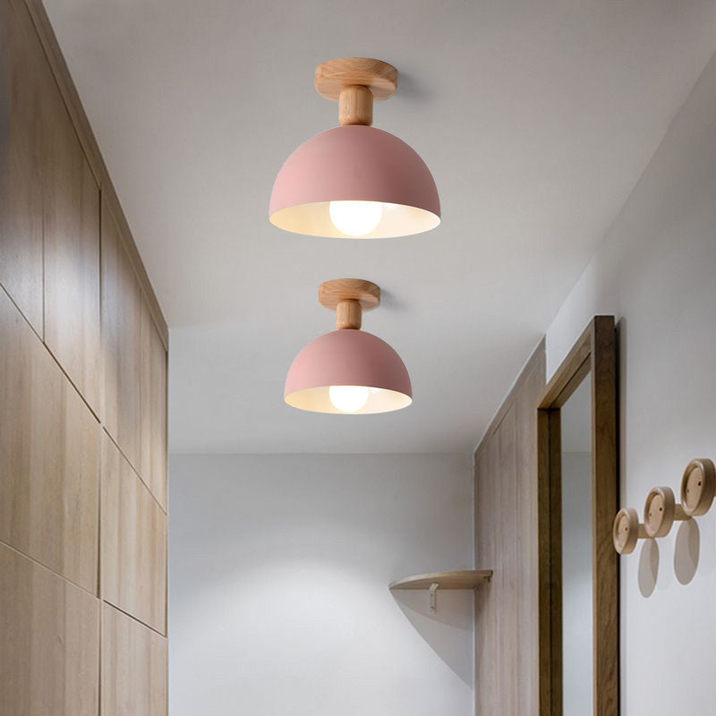 Pink Ozawa Dome ceiling lights with open undersides and visible bulbs, hallway wood cabinet, mirror and circular wall hooks