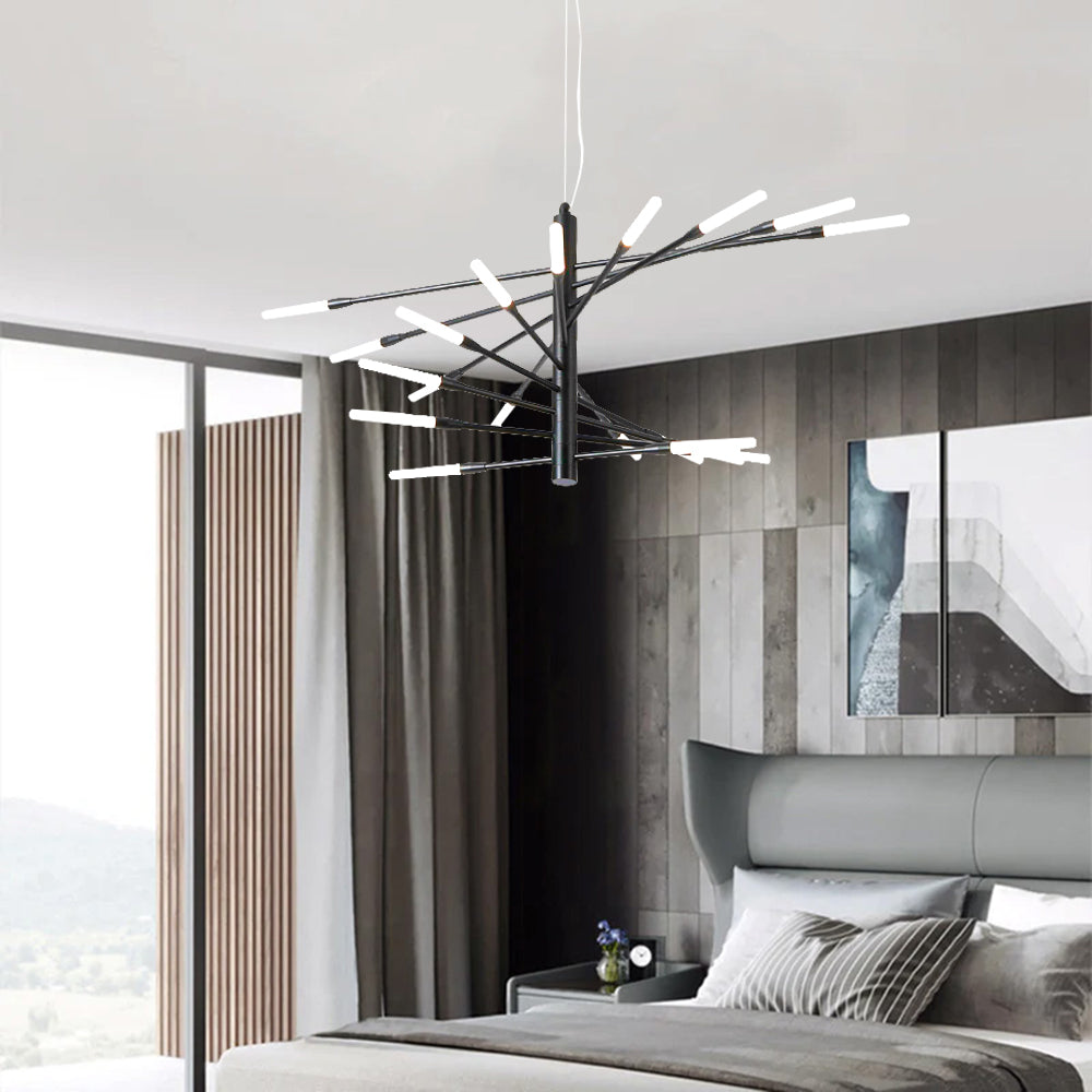 Black Lowry chandelier above gray bed with striped pillow and paneled wall, abstract frames at right and large window at left