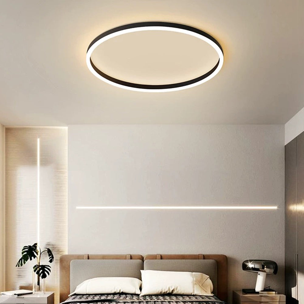 Black Arisha above a beige bed, decorative wall lighting, a leafy vase and a separate domed bedside table lamp.