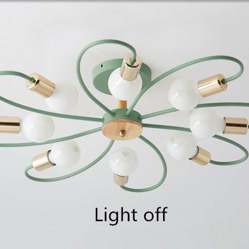Green eight-head ceiling light switched off, with white globe bulbs, looped arms and gold-tone holders