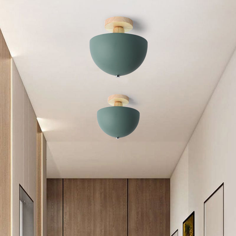 Two green Ozawa Bowl ceiling lights with rounded undersides and small finials, wood cabinetry and framed prints in hallway
